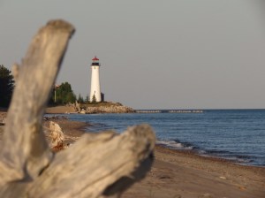 Crisp Point lighthouse through driftwood